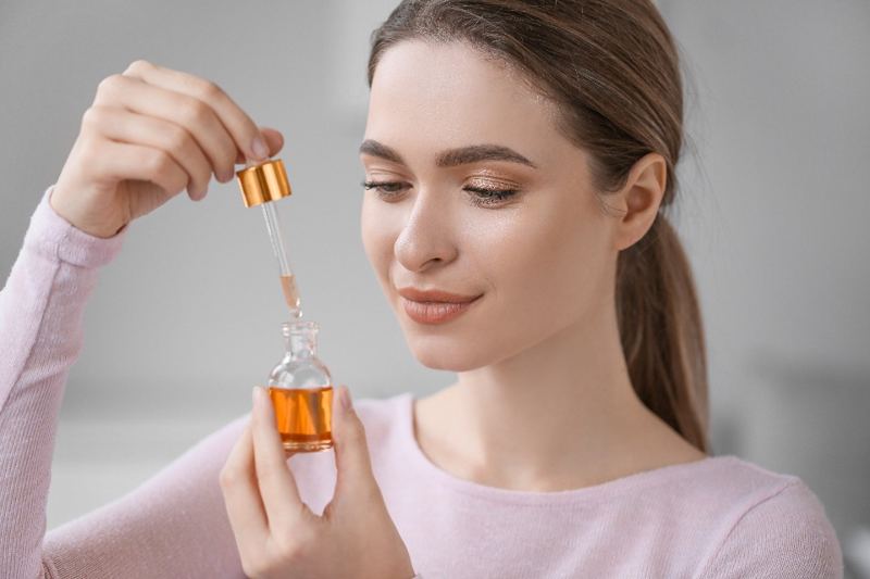 Woman holding a cosmetic serum dropper